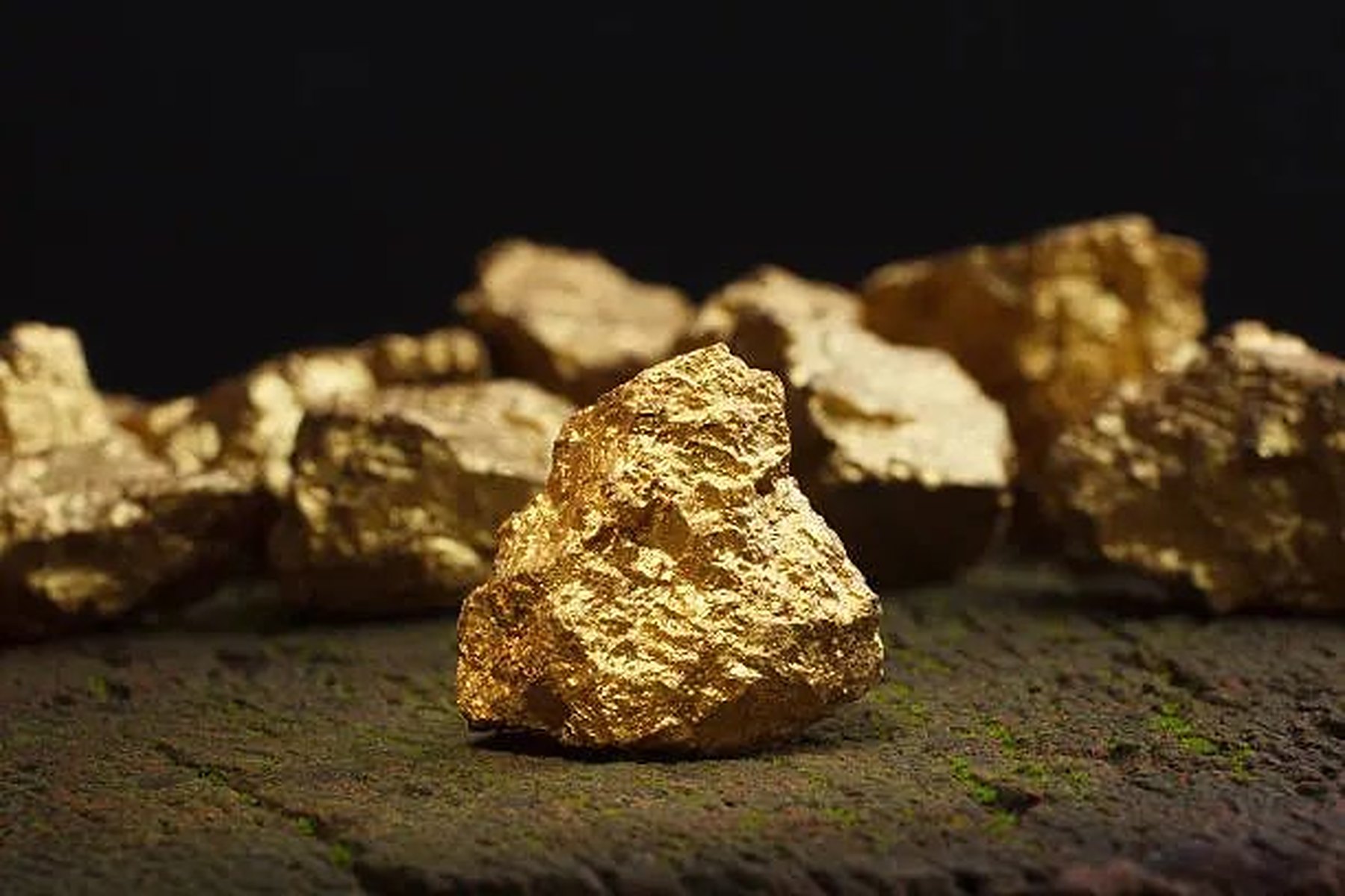Raw gold nuggets on a dark surface