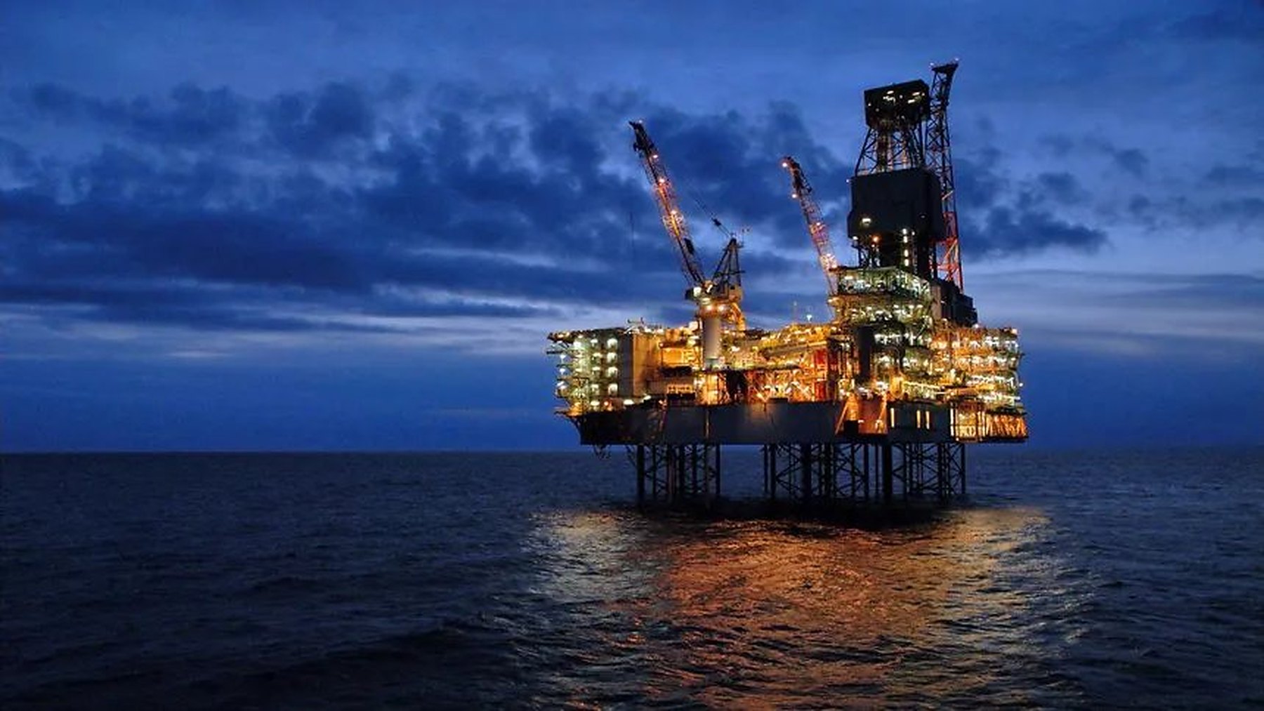Offshore oil platform lit at dusk