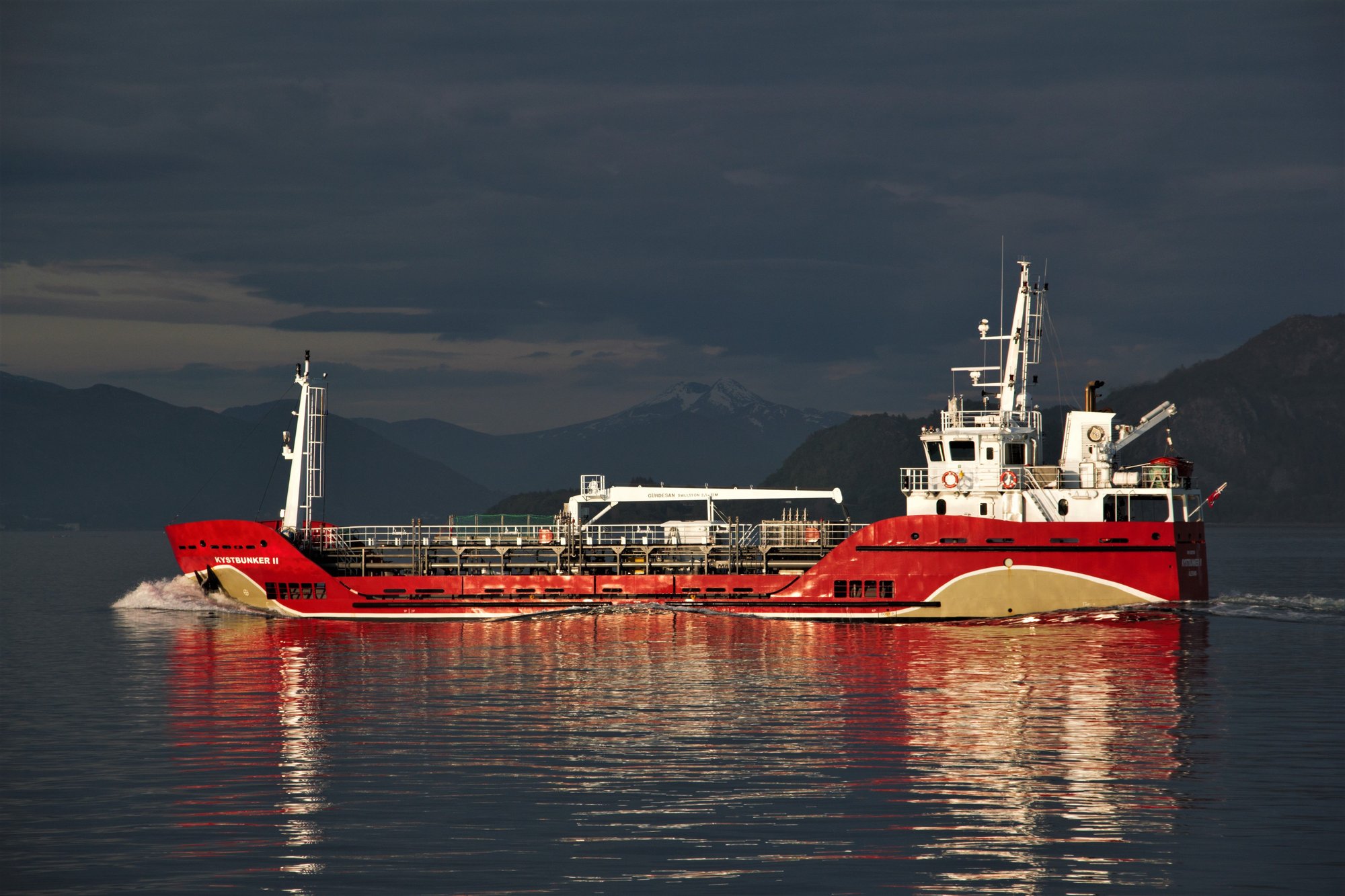 Red oil products tanker sailing at dusk