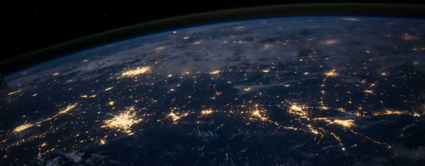 Earth at night from orbit, with city lights tracing trade routes