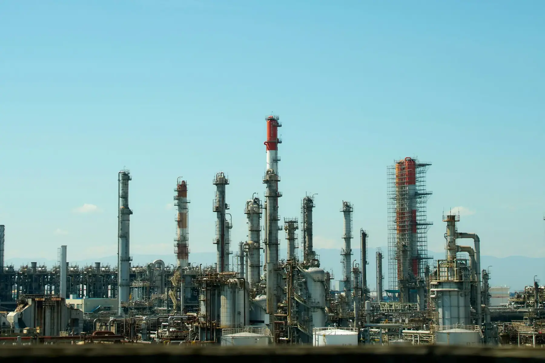 Petroleum refinery distillation towers against a clear sky